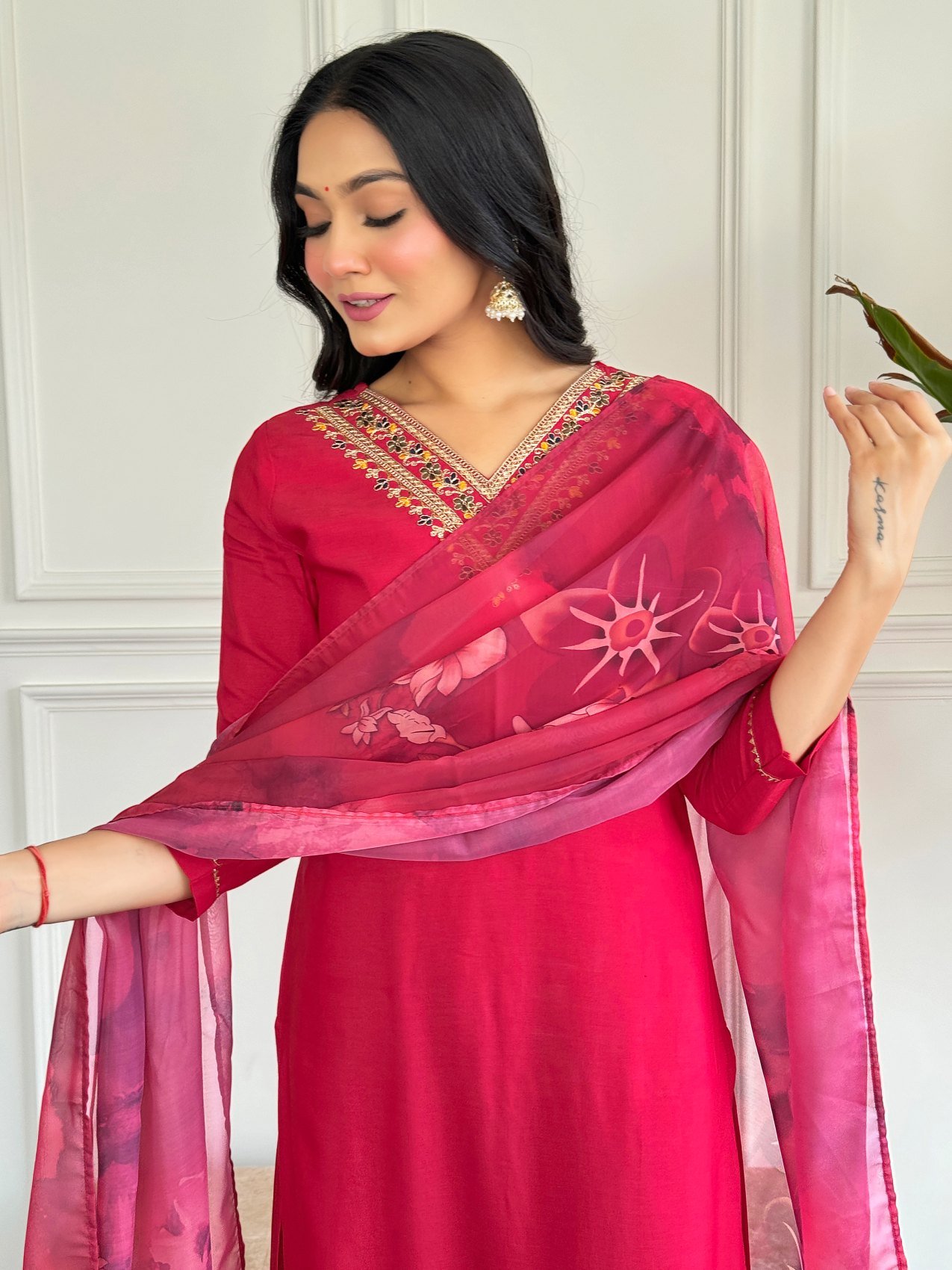 Close-up of the printed silk dupatta held open beside the red kurta