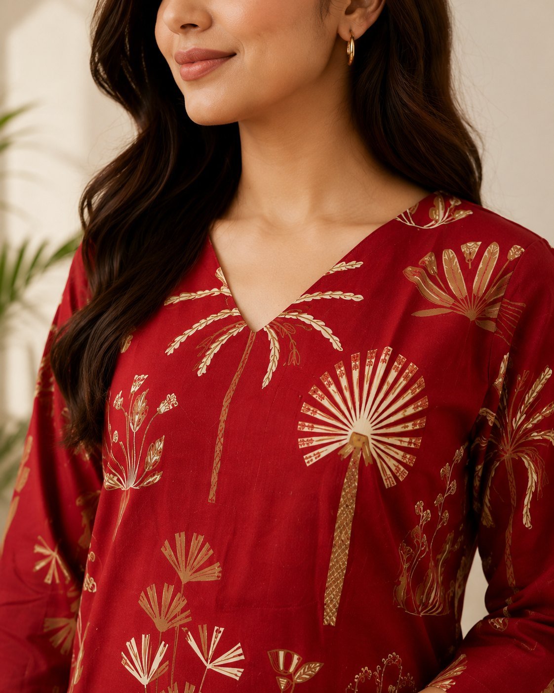 Close-up of the notch V-neckline and golden foil print on the red kurta
