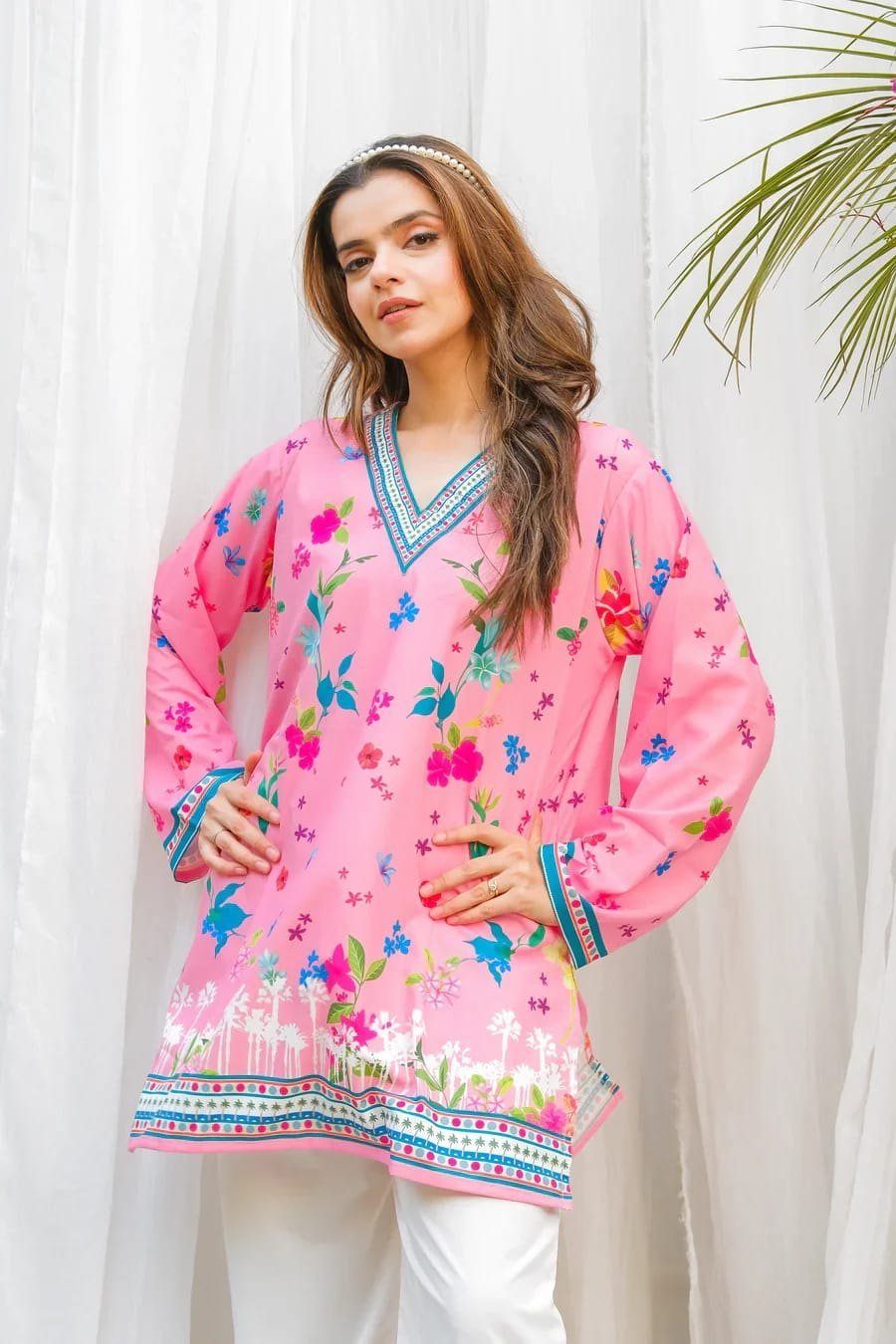 Close-up of the floral print and contrast V-neckline border on the pink kurti