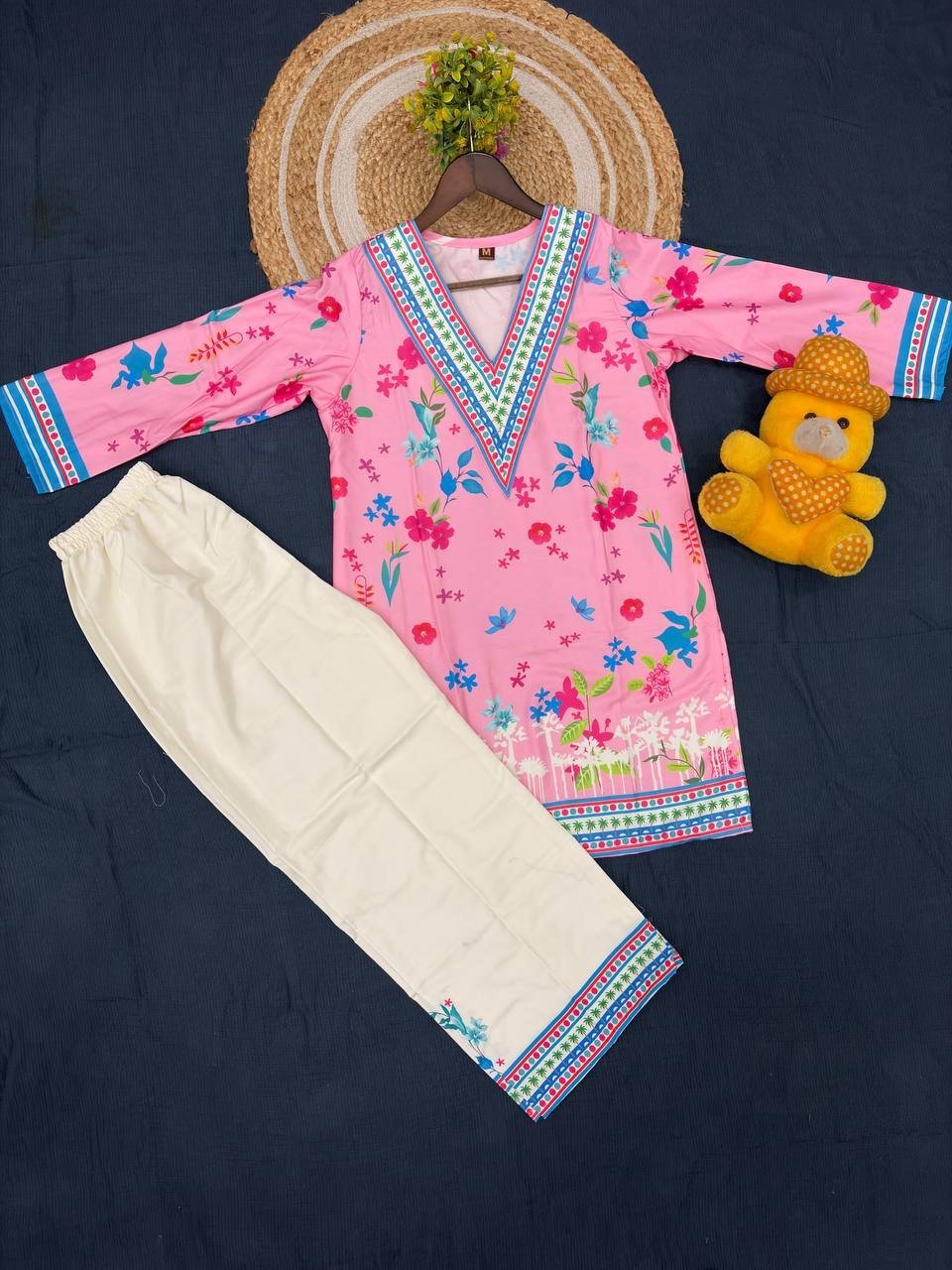 Flat lay showing both pieces: the pink printed kurti and cream pant with printed border