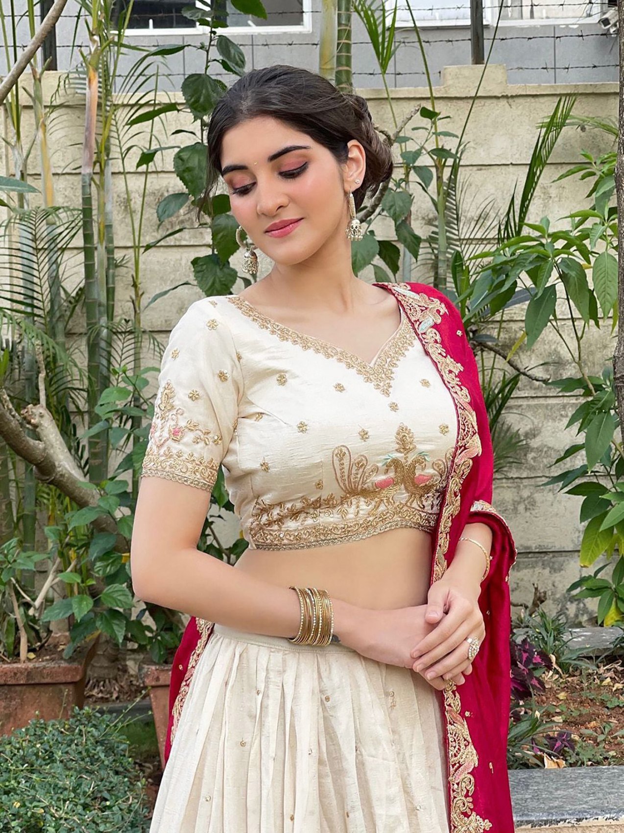 Ivory zari embroidered Chinon semi-stitched lehenga choli set with red dupatta, close-up of the zari embroidered choli and lehenga border