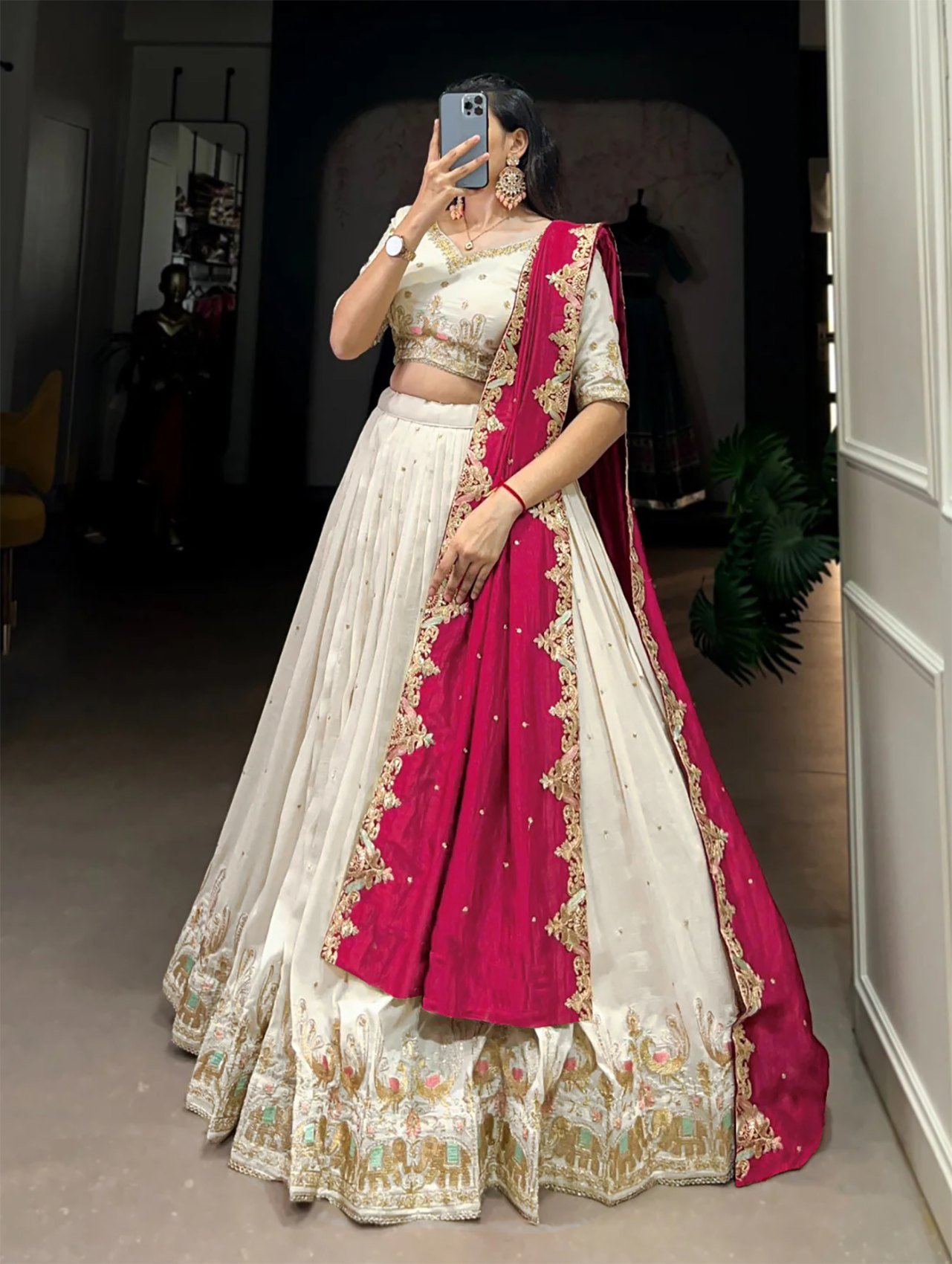 Ivory zari embroidered Chinon semi-stitched lehenga choli set with red dupatta, front view of the ivory lehenga with embroidered hem border