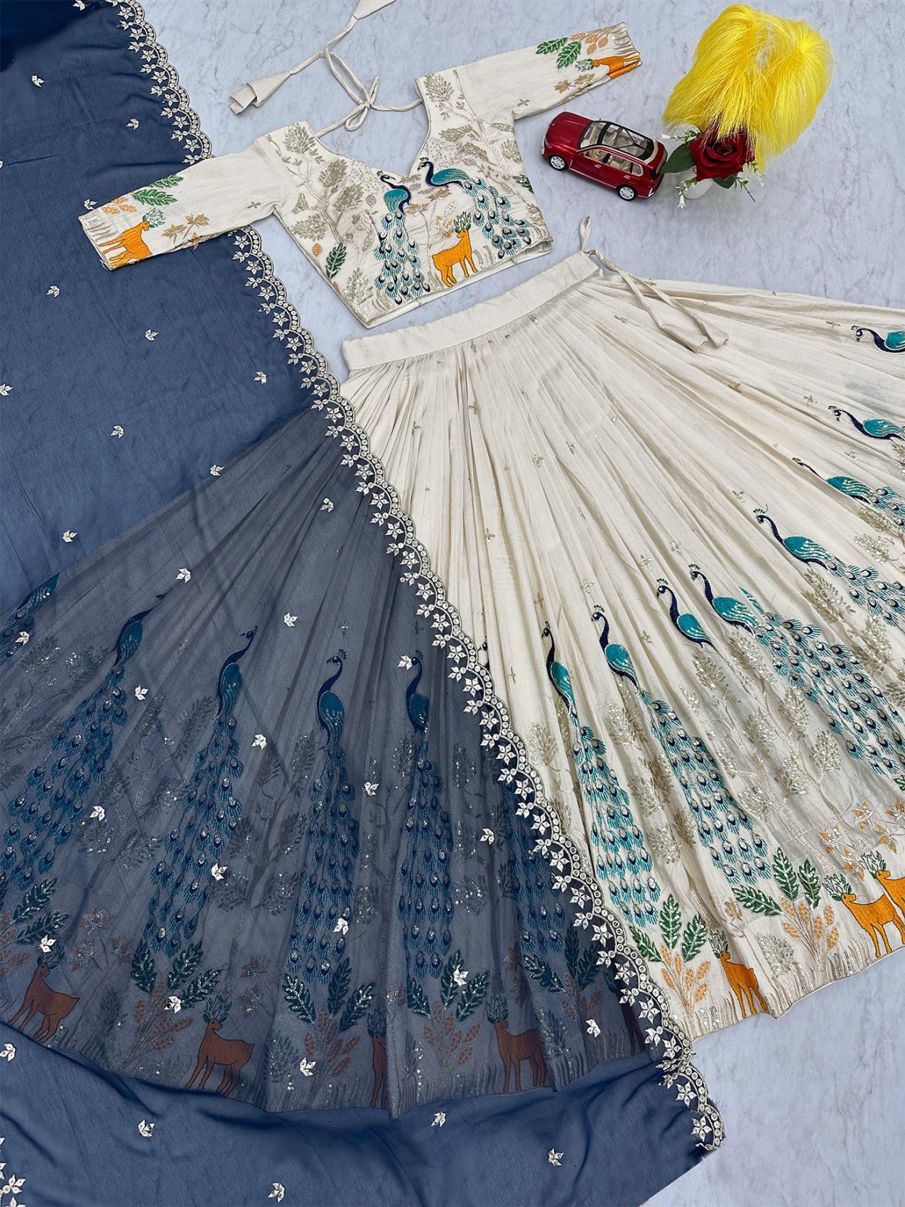 Flat lay showing the lehenga, un-stitched blouse piece and dupatta