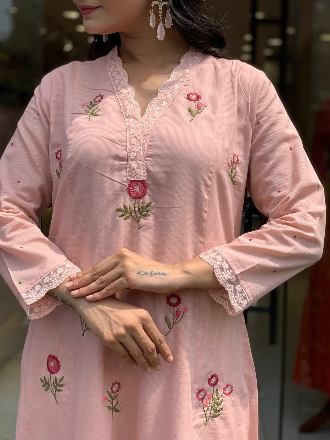Close-up of the floral embroidery and mandarin collar on the peach kurta