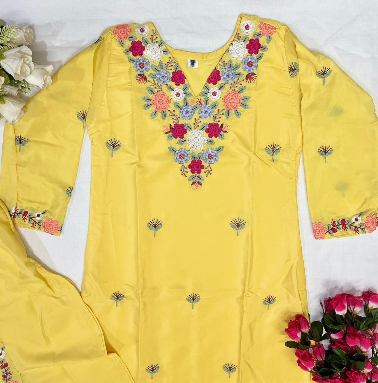 Flat lay close-up of the embroidery on the yellow kurti