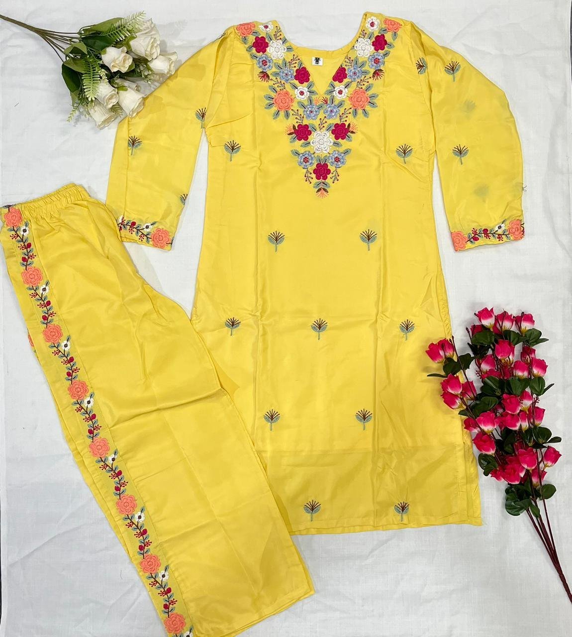 Flat lay showing the yellow embroidered kurti with its matching pant