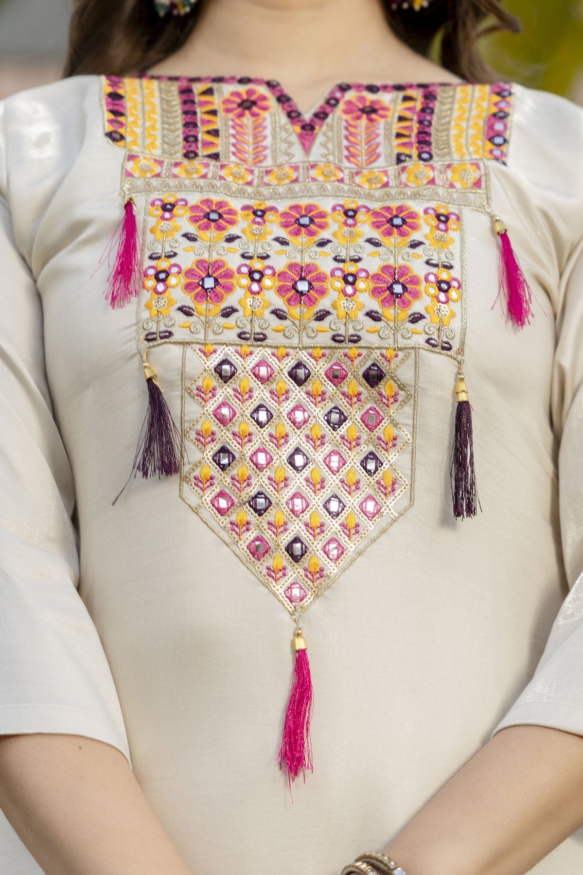 Close-up of the embroidered yoke panel with tassels on the cream kurta