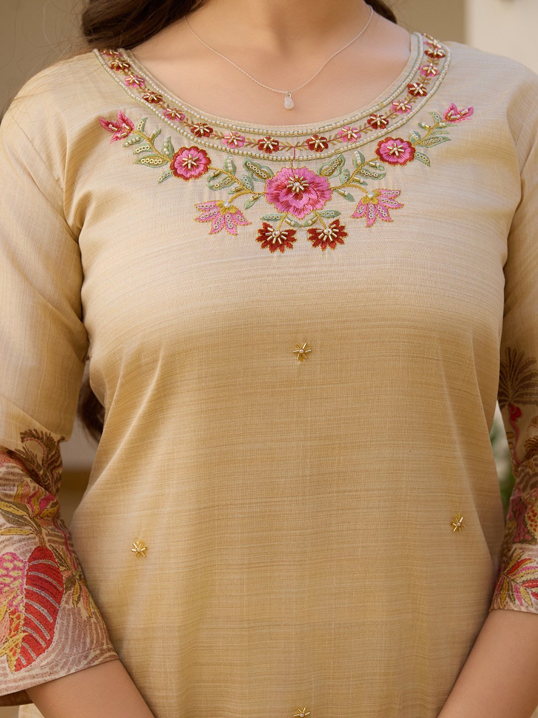 Close-up of the rose and bead embroidery around the neckline of the beige kurta