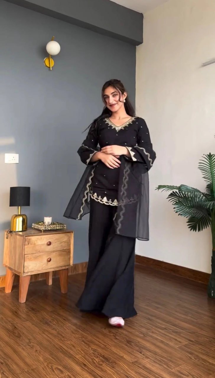 Black silk crepe kurta set with organza dupatta draped over both arms