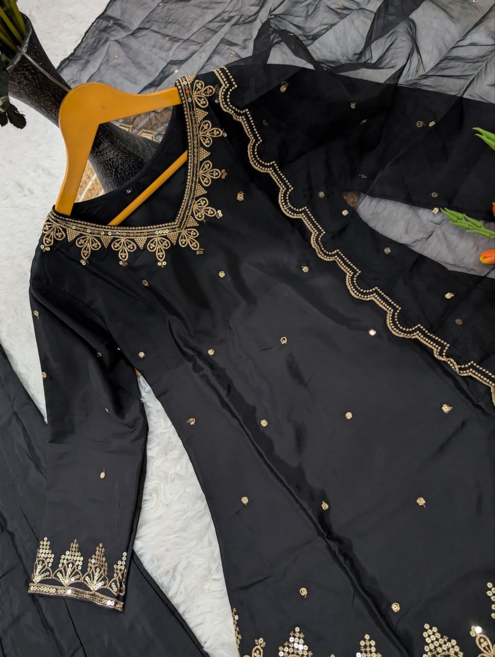 Close-up of gold-tone V-neck embroidery and sequin buttis on black silk crepe kurta