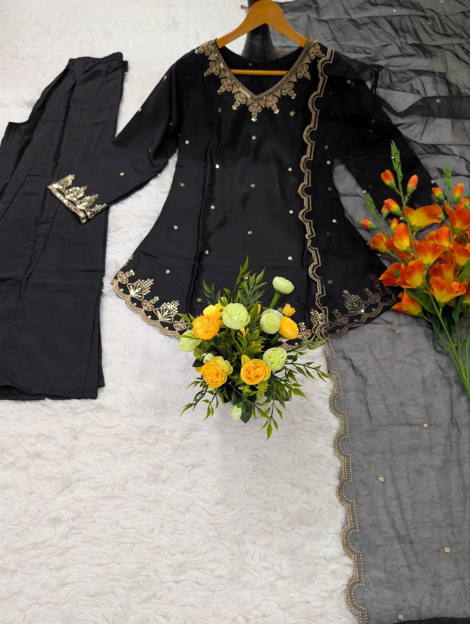 Flat lay of black kurta with embroidered sleeve cuff and scalloped organza dupatta border