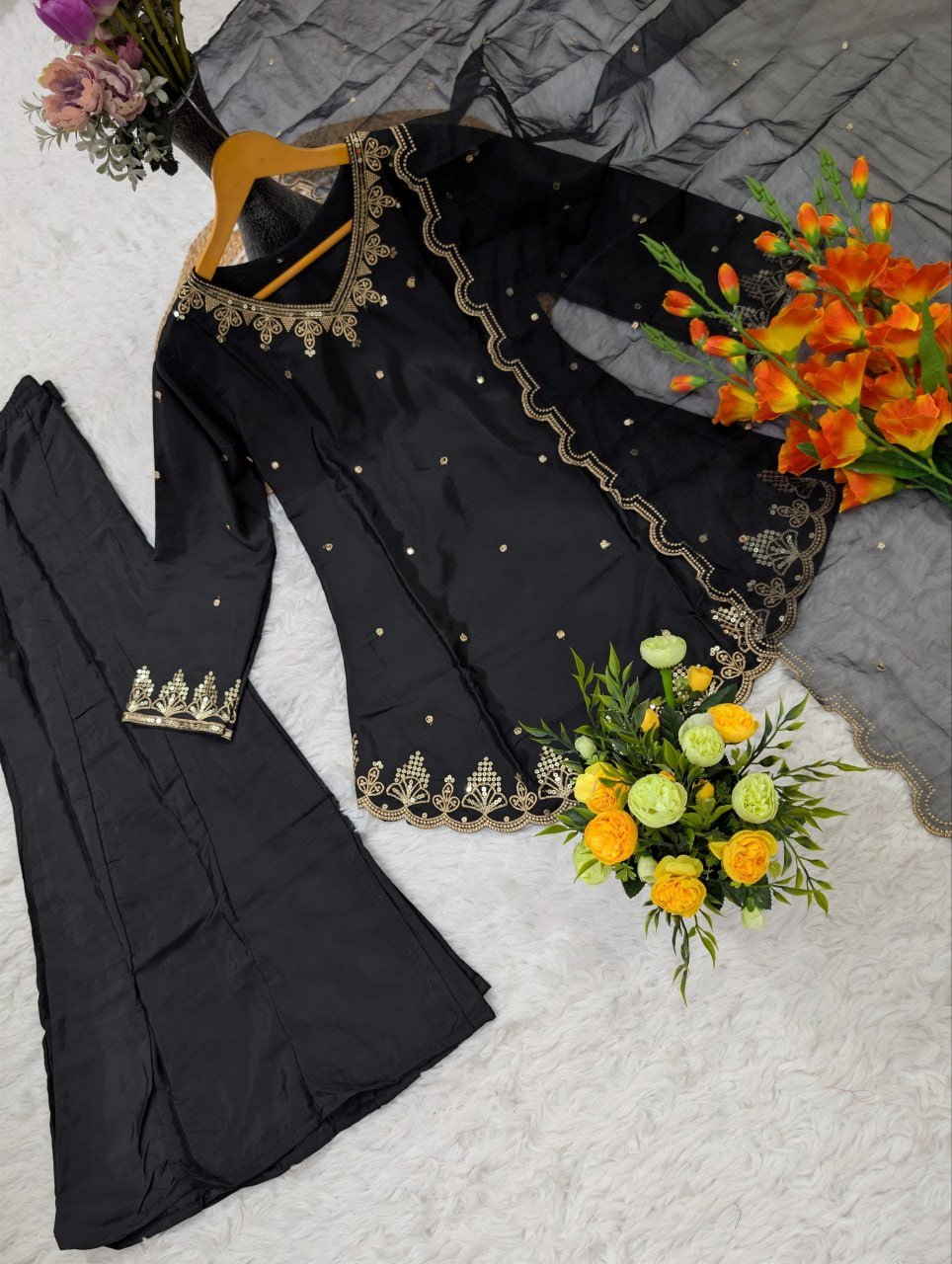 Flat lay of black embroidered kurta with wide-leg pant and organza dupatta